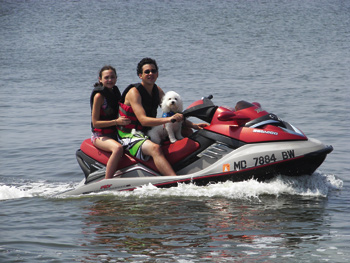 Madi, her brother Levi, and Blizzard enjoy a ride on a personal watercraft last summer.