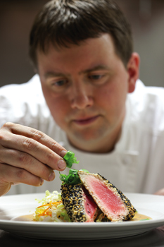 Executive chef Eric Huntley garnishes a sesame-encrusted saku tuna. Photograph by Thom Thompson